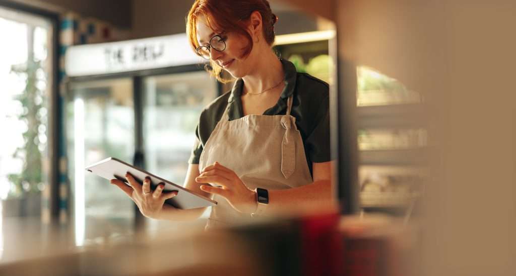 Retail manager using energy monitoring tablet to reduce retail energy costs through real-time data analysis in store